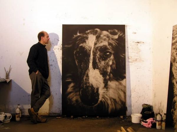 Piotr Wojcik à côté d'une peinture de barzoï.